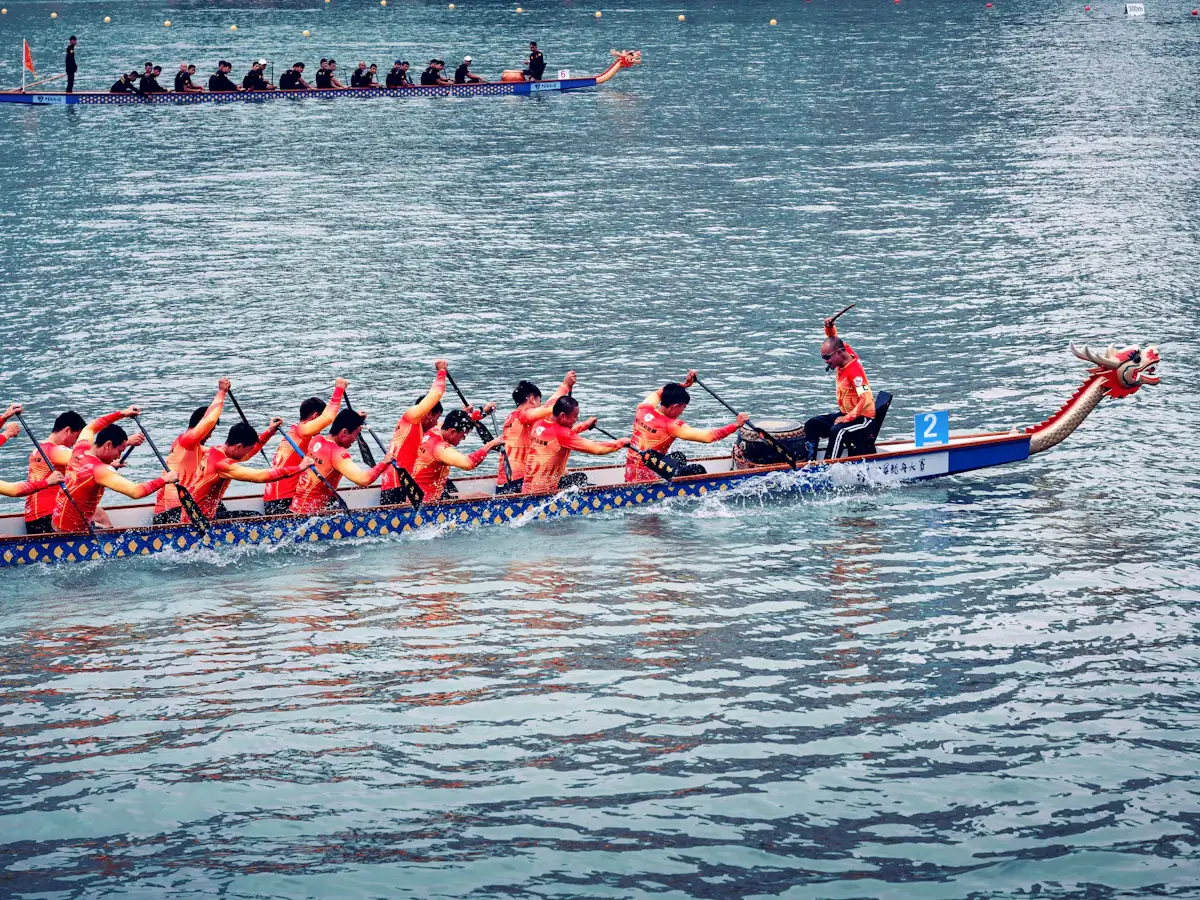 A dragon boat crew paddling hard across open water