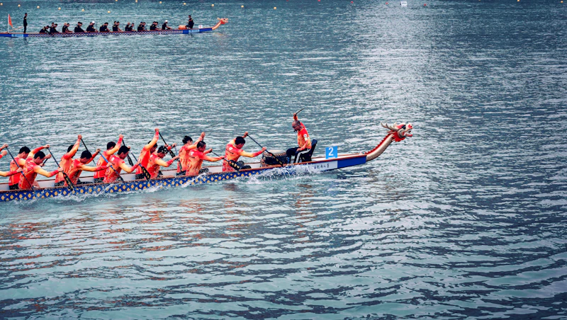 A dragon boat crew racing across the water