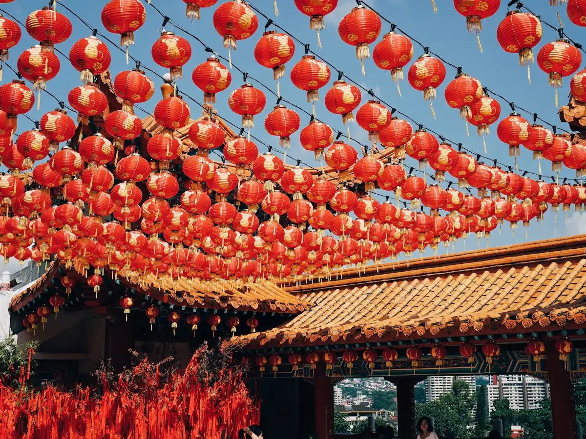 Rows of red lanterns strung above a temple courtyard