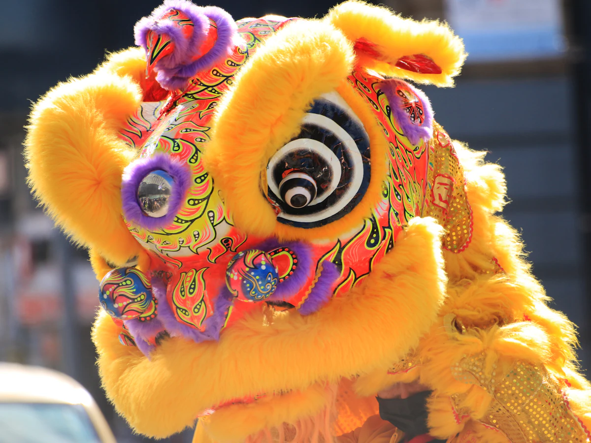 A yellow lion dance head up close