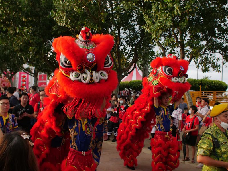 Two red lion dancers performing at a street festival