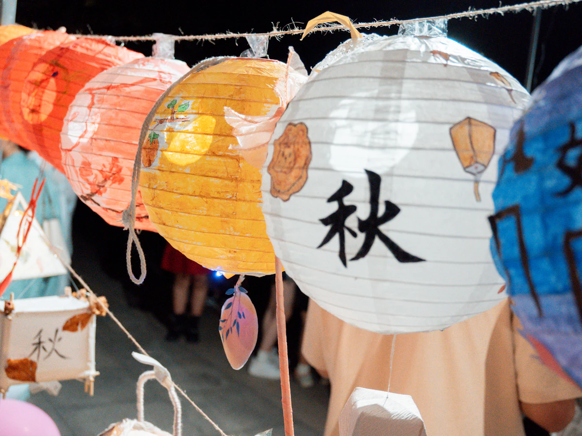 Paper lanterns painted with Chinese characters, including 秋 for autumn