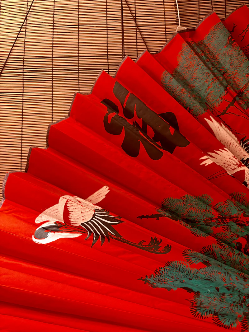 A red folding fan painted with cranes